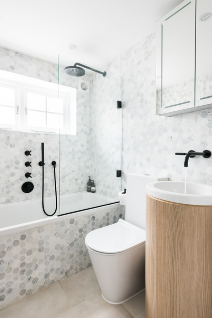 на фото зображено варіант інтер'єру ванної кімнати з повним облицюванням керамічною плиткою стін та підлоги при гарному природному освітленні