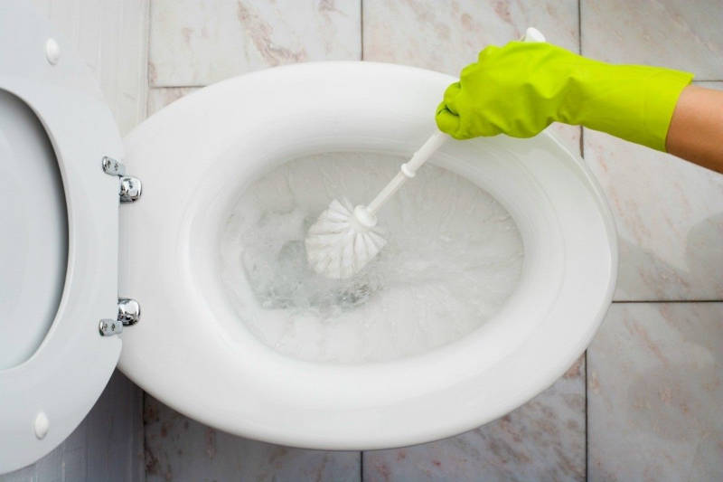 на фото зображено унітаз, який чистять йоржиком за допомогою професійного засобу для клінінгу