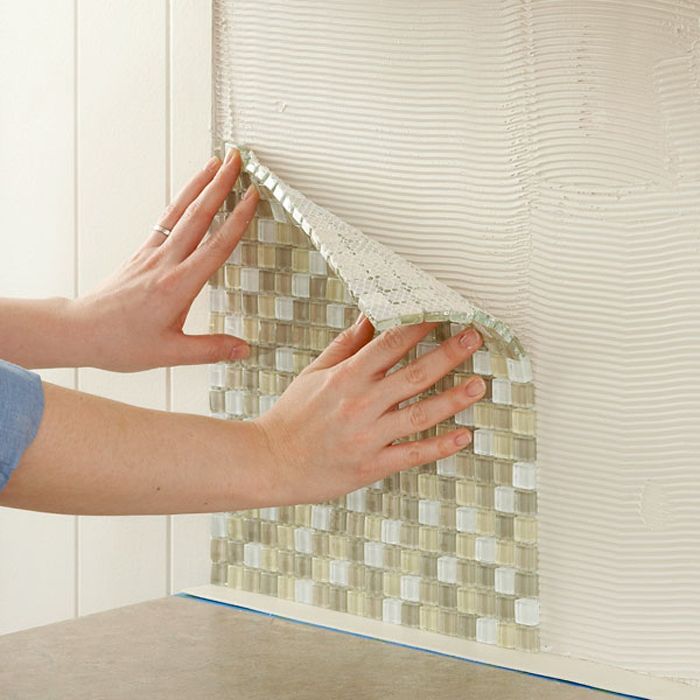 процесс укладки плитки мозаики на стену, фото